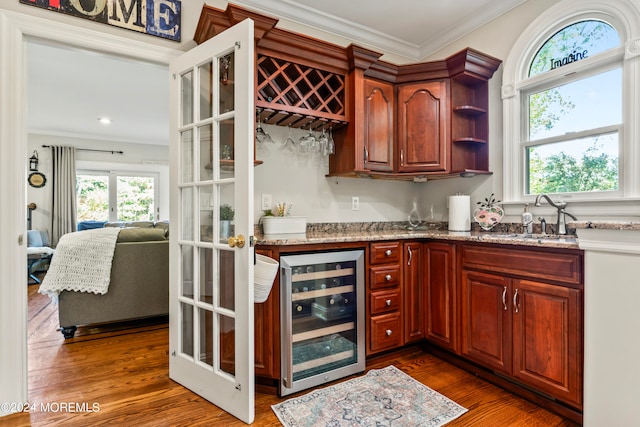 bar featuring a wealth of natural light, dark hardwood / wood-style floors, and beverage cooler