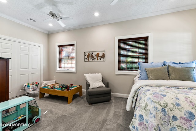 carpeted bedroom featuring a closet, ceiling fan, and a textured ceiling