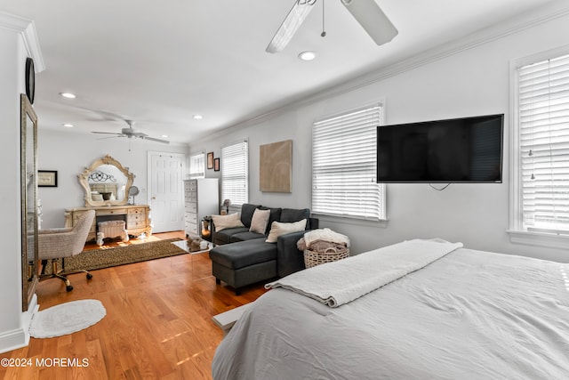 bedroom featuring wood-type flooring, multiple windows, and ornamental molding