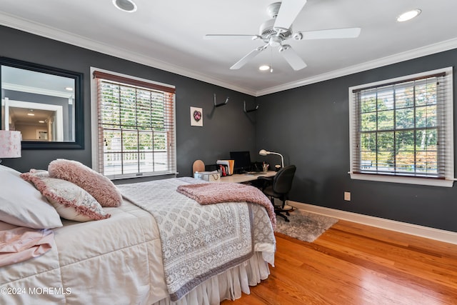 bedroom with ceiling fan, wood-type flooring, multiple windows, and ornamental molding