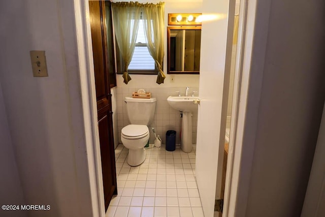 133 Degraw Ave, Teaneck, NJ 07666 - bathroom with tile patterned floors, toilet, a sink, and tile walls