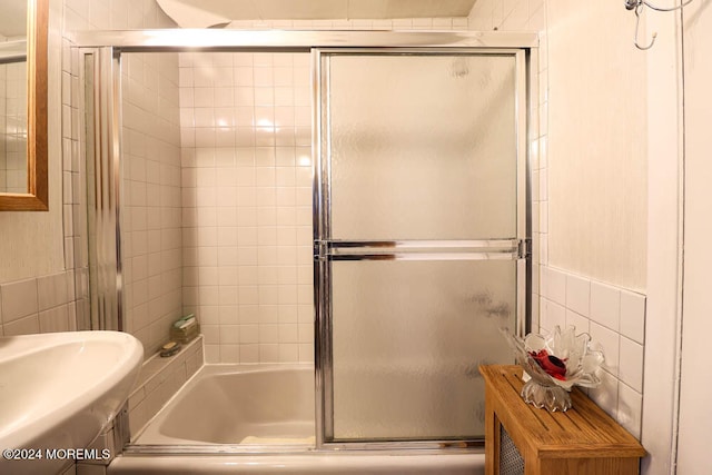 bathroom with enclosed tub / shower combo and tile walls