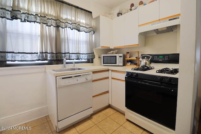 133 Degraw Ave, Teaneck, NJ 07666 - kitchen with white appliances, a sink, under cabinet range hood, light tile patterned floors, and white cabinetry