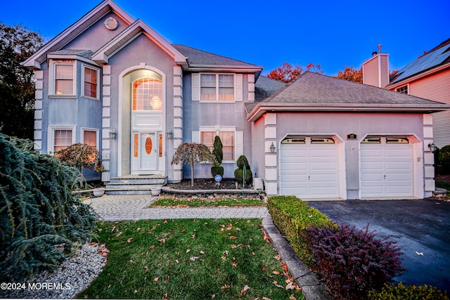 front of property featuring a front yard and a garage