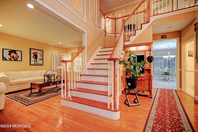 stairway featuring hardwood / wood-style flooring and a chandelier