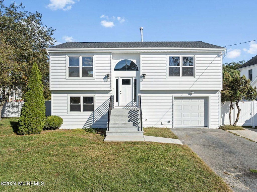 bi-level home with a front lawn and a garage