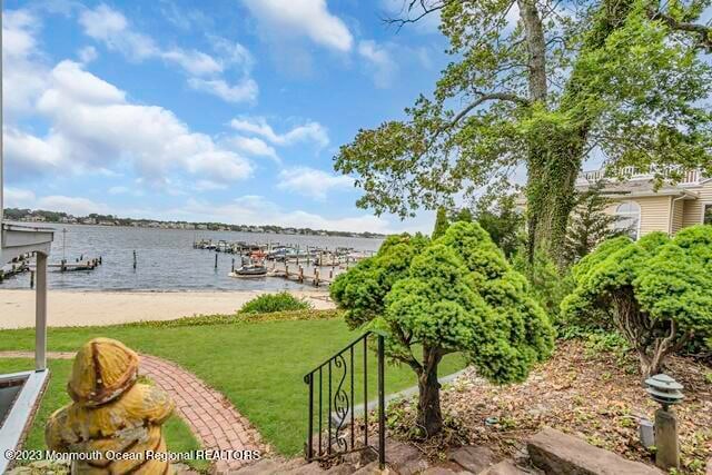 view of dock featuring a water view and a lawn