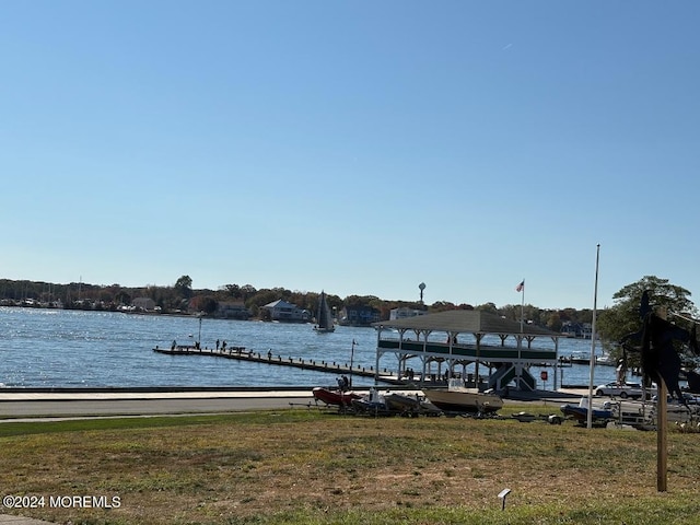 view of dock featuring a water view and a yard