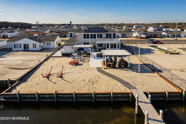 rear view of property featuring a water view and a patio area