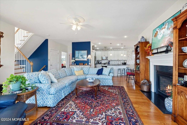 living room with ceiling fan and light wood-type flooring