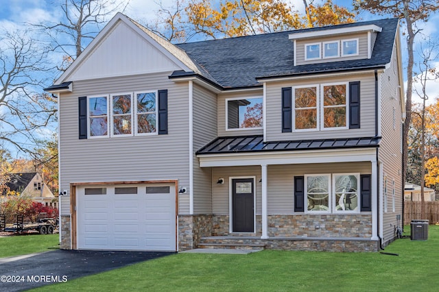 view of front facade featuring a garage, central air condition unit, and a front yard