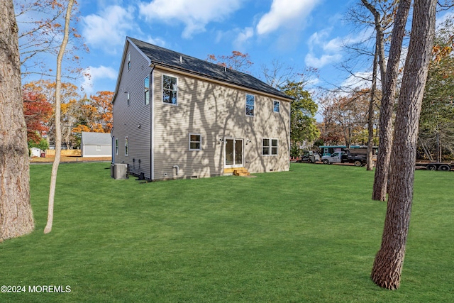 rear view of property with a yard and central air condition unit