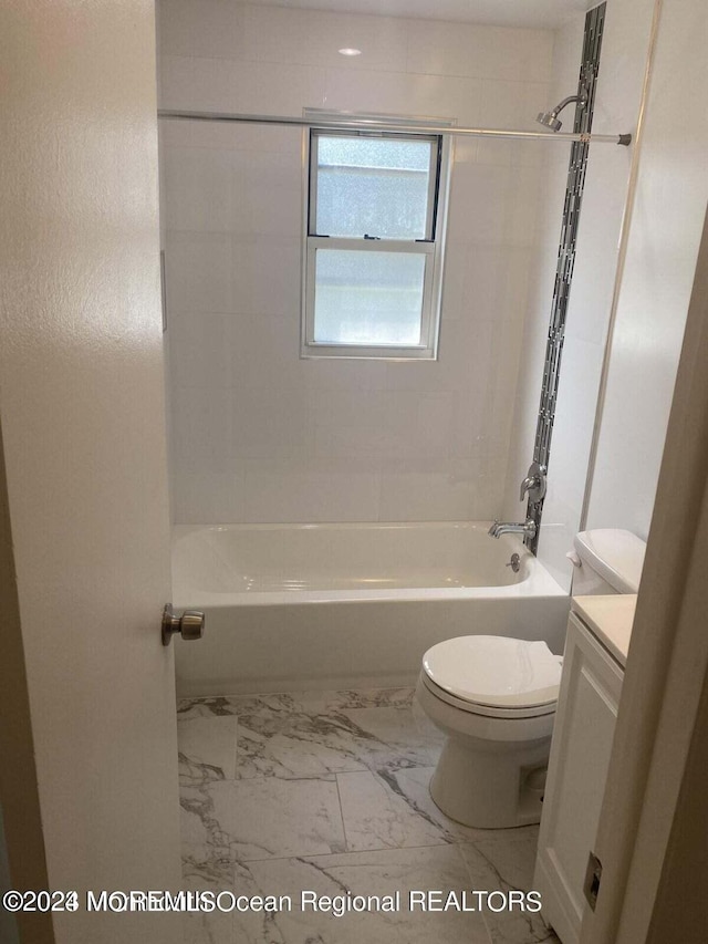 full bathroom featuring vanity, tiled shower / bath combo, and toilet