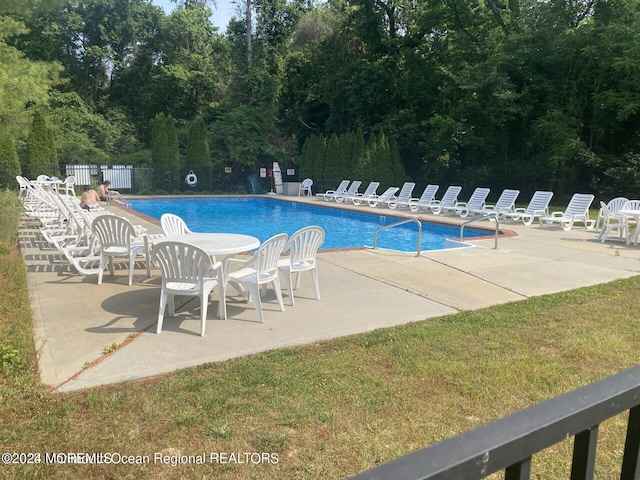 view of pool featuring a patio area and a yard