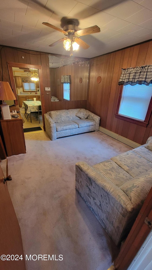 carpeted bedroom with wooden walls and ceiling fan