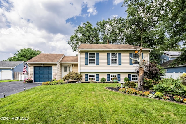 tri-level home with a garage and a front yard