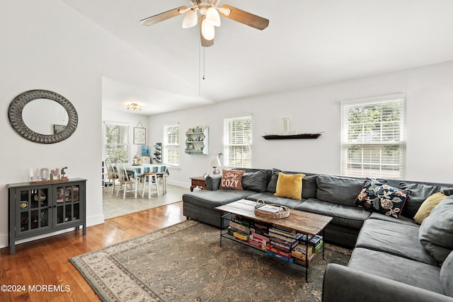 living room with ceiling fan, lofted ceiling, a healthy amount of sunlight, and hardwood / wood-style floors