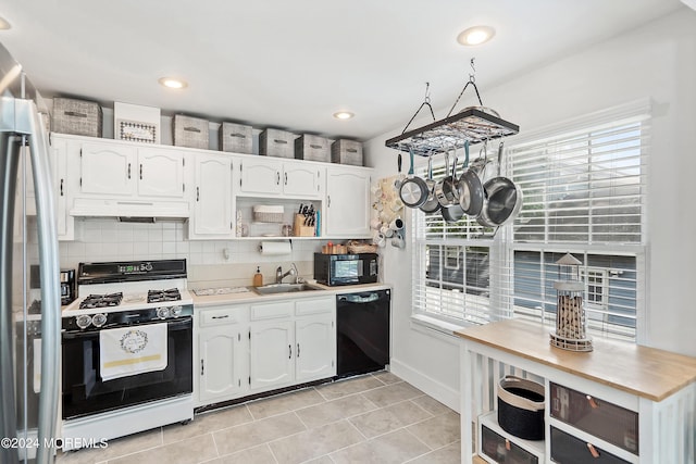 kitchen with decorative backsplash, sink, white cabinets, and black appliances