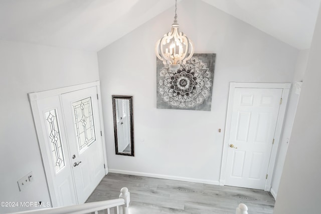 entrance foyer with lofted ceiling, an inviting chandelier, and light hardwood / wood-style floors