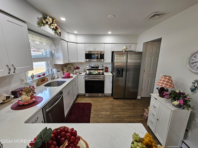 kitchen featuring appliances with stainless steel finishes, dark hardwood / wood-style floors, white cabinets, and a baseboard radiator