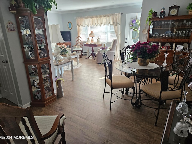 dining area featuring ornamental molding and wood-type flooring