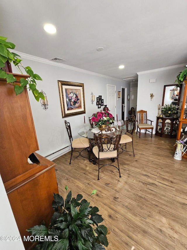 dining room with crown molding, wood-type flooring, and a baseboard radiator