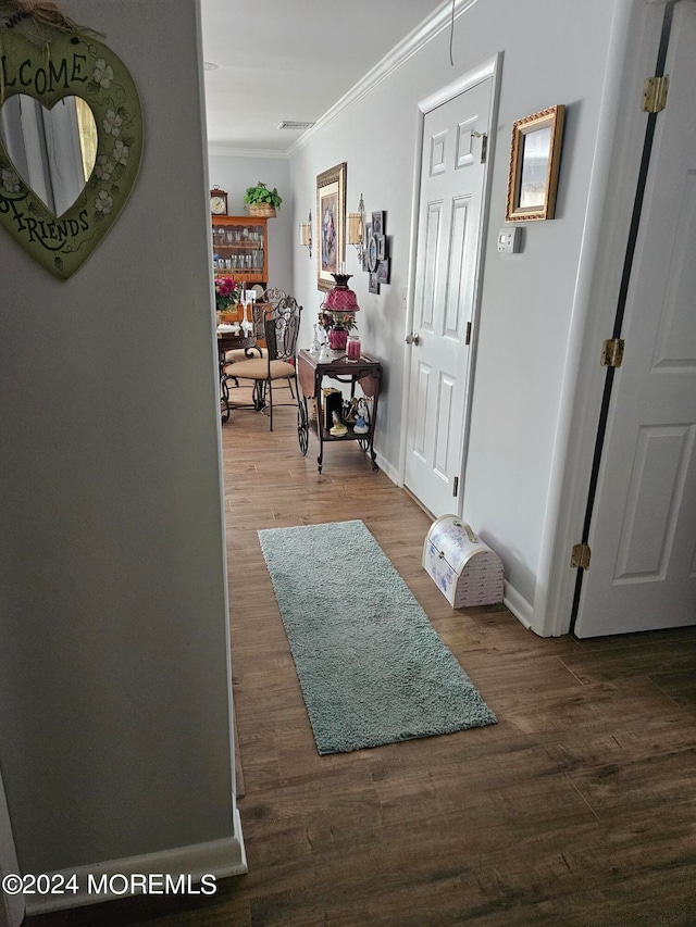 corridor with crown molding and wood-type flooring