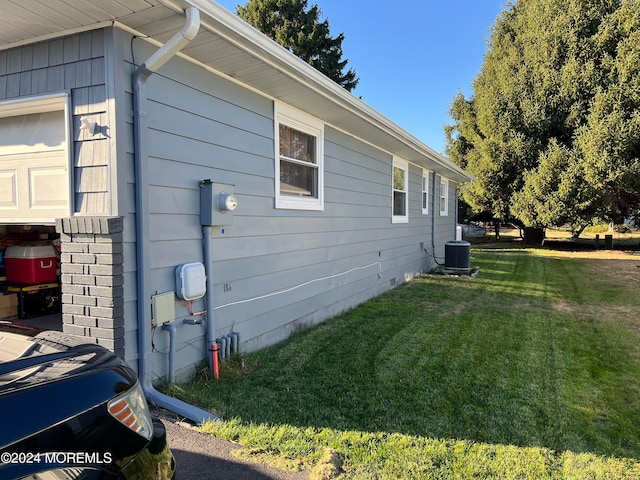 view of home's exterior with a yard and central air condition unit