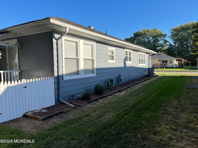 view of side of home with a yard