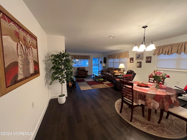 dining space featuring hardwood / wood-style floors and an inviting chandelier