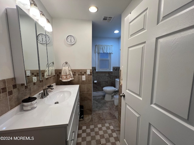 bathroom with vanity, a baseboard radiator, tile walls, and toilet