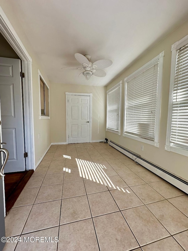 interior space featuring baseboard heating, ceiling fan, and light tile patterned flooring