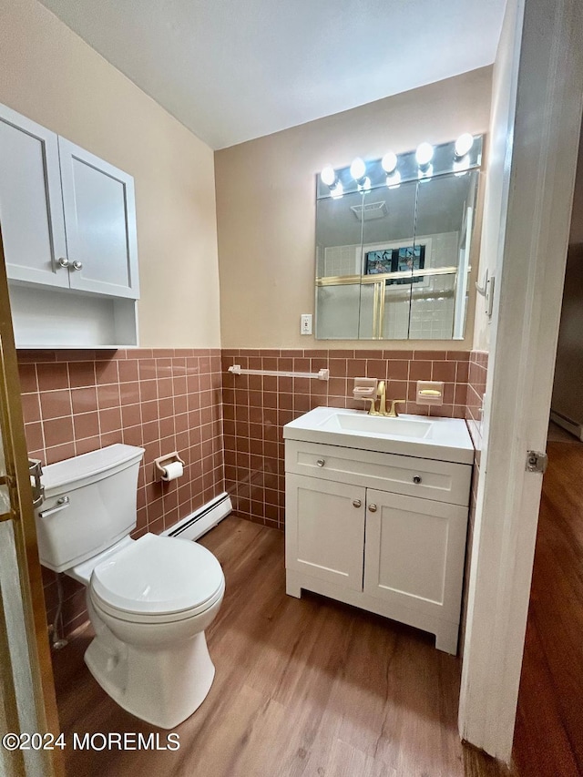 bathroom featuring toilet, tile walls, a baseboard radiator, vanity, and hardwood / wood-style flooring