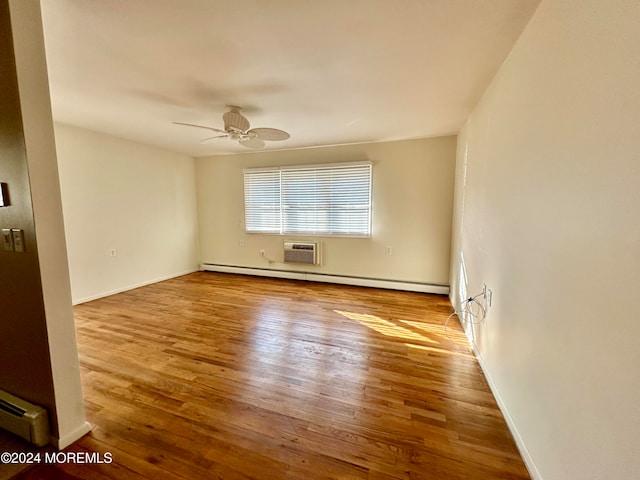 spare room with hardwood / wood-style flooring, a baseboard radiator, and ceiling fan