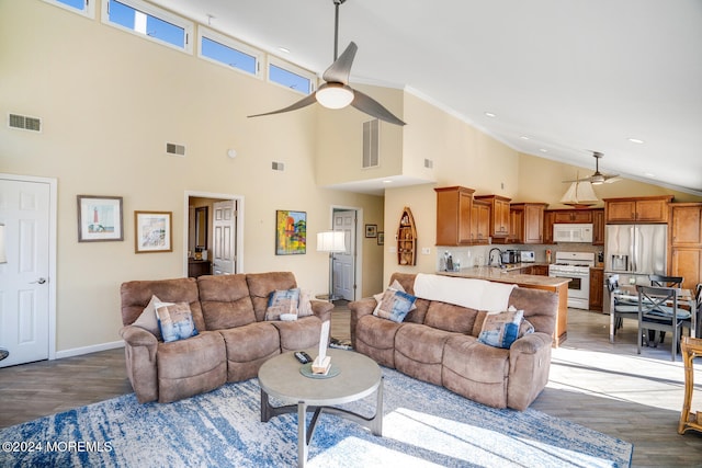 living room featuring ornamental molding, hardwood / wood-style floors, a high ceiling, and ceiling fan