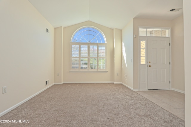 foyer with light carpet and vaulted ceiling