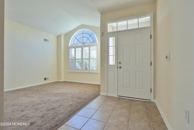 carpeted foyer entrance featuring lofted ceiling