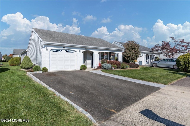 view of front of home with a front yard and a garage