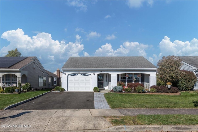 view of front of property featuring a front yard and a garage