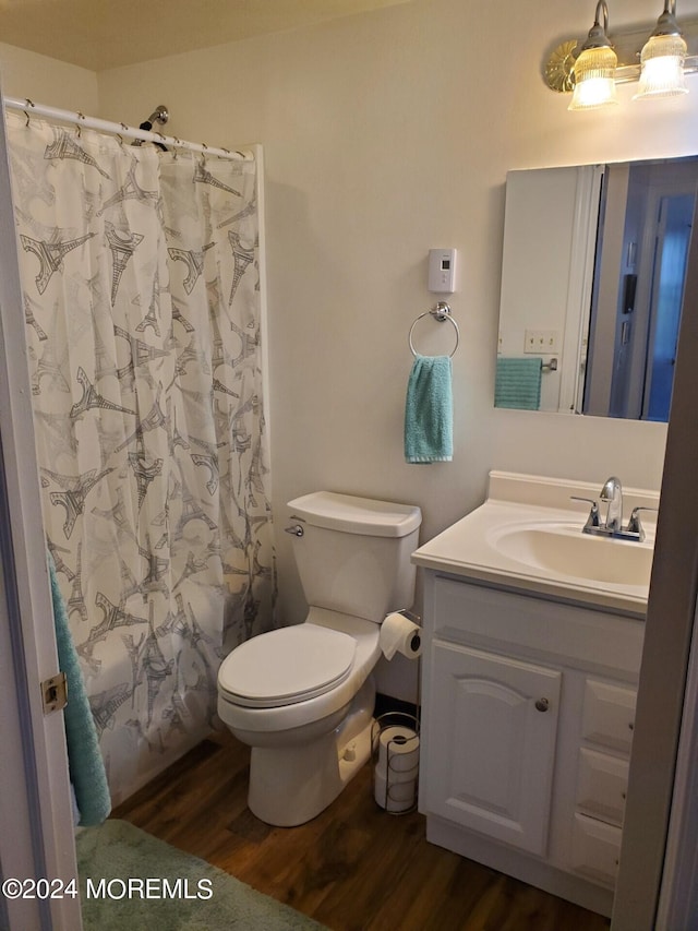 full bathroom featuring toilet, shower / bath combo, hardwood / wood-style flooring, and vanity