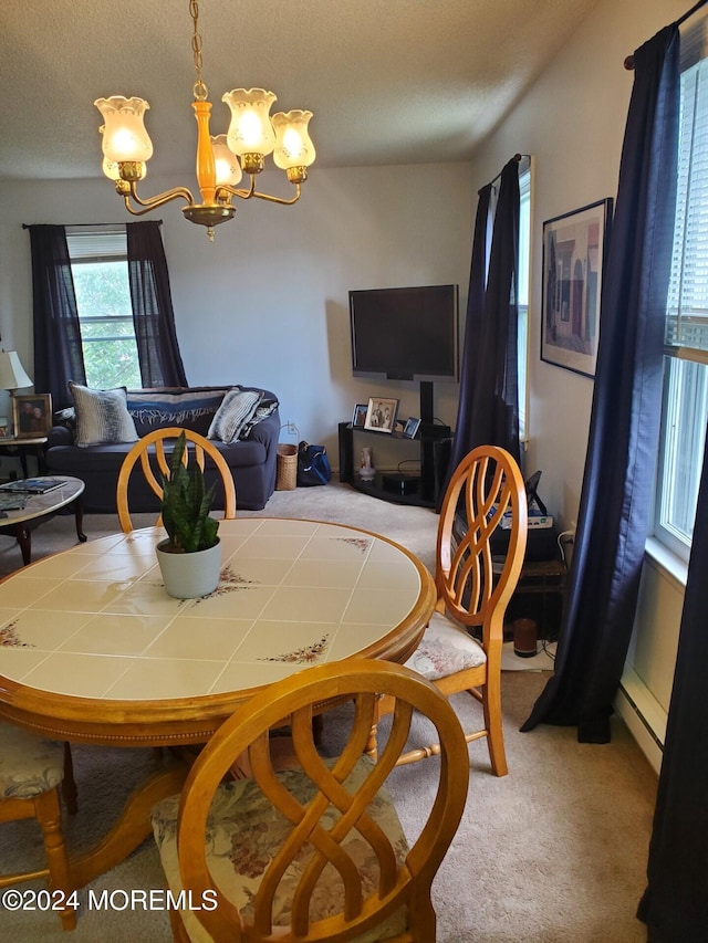 dining space featuring a notable chandelier, a textured ceiling, carpet floors, and a baseboard heating unit