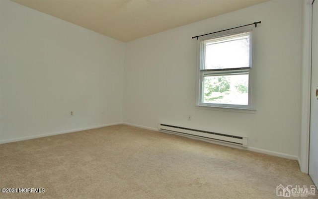 unfurnished room featuring a baseboard heating unit and light colored carpet