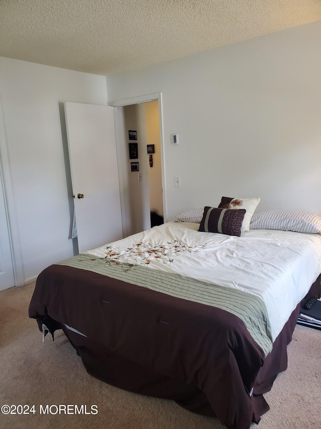 carpeted bedroom featuring a textured ceiling