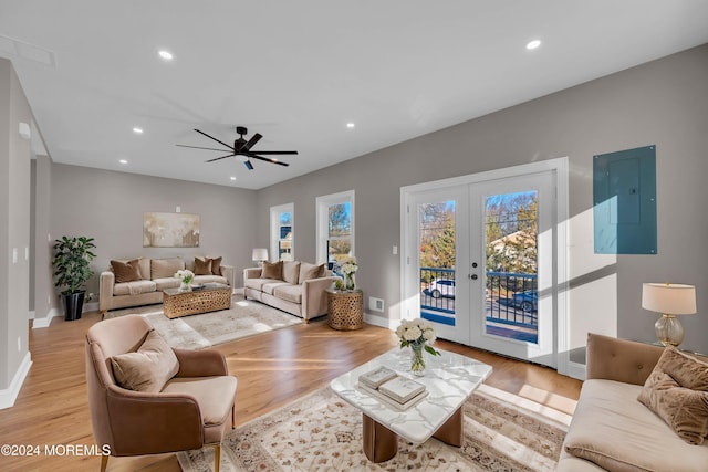 living room with french doors, light wood-type flooring, electric panel, and ceiling fan