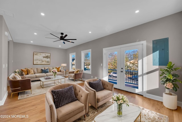 living room featuring french doors, electric panel, light hardwood / wood-style floors, and ceiling fan