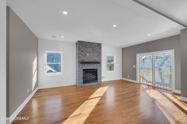 unfurnished living room featuring light wood-type flooring and a fireplace