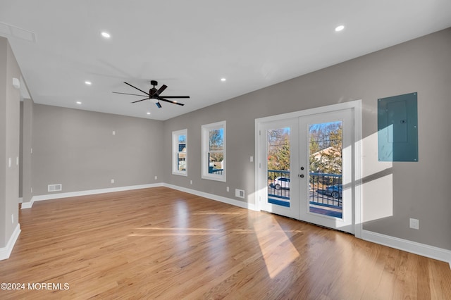 unfurnished living room featuring french doors, light wood-type flooring, electric panel, and ceiling fan