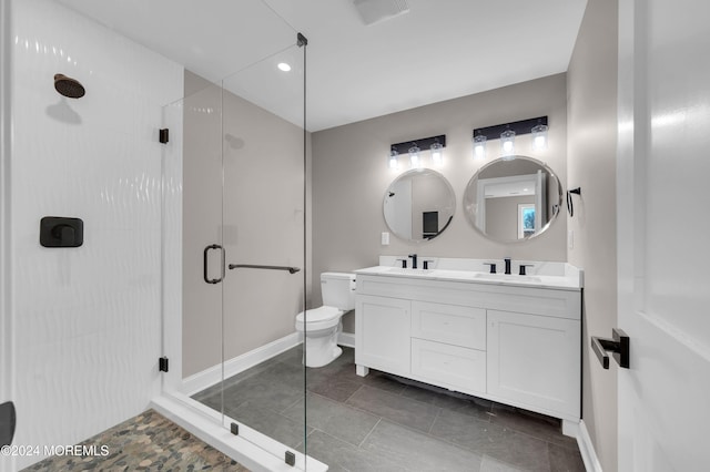 bathroom with vanity, toilet, and a shower with shower door