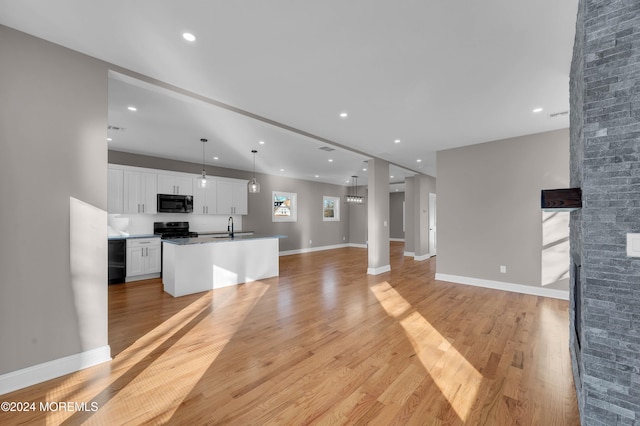 unfurnished living room featuring sink and light wood-type flooring