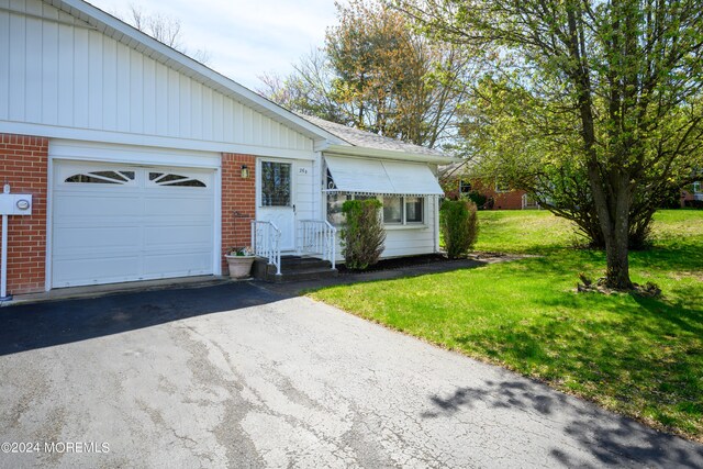 view of front of home featuring a front yard and a garage